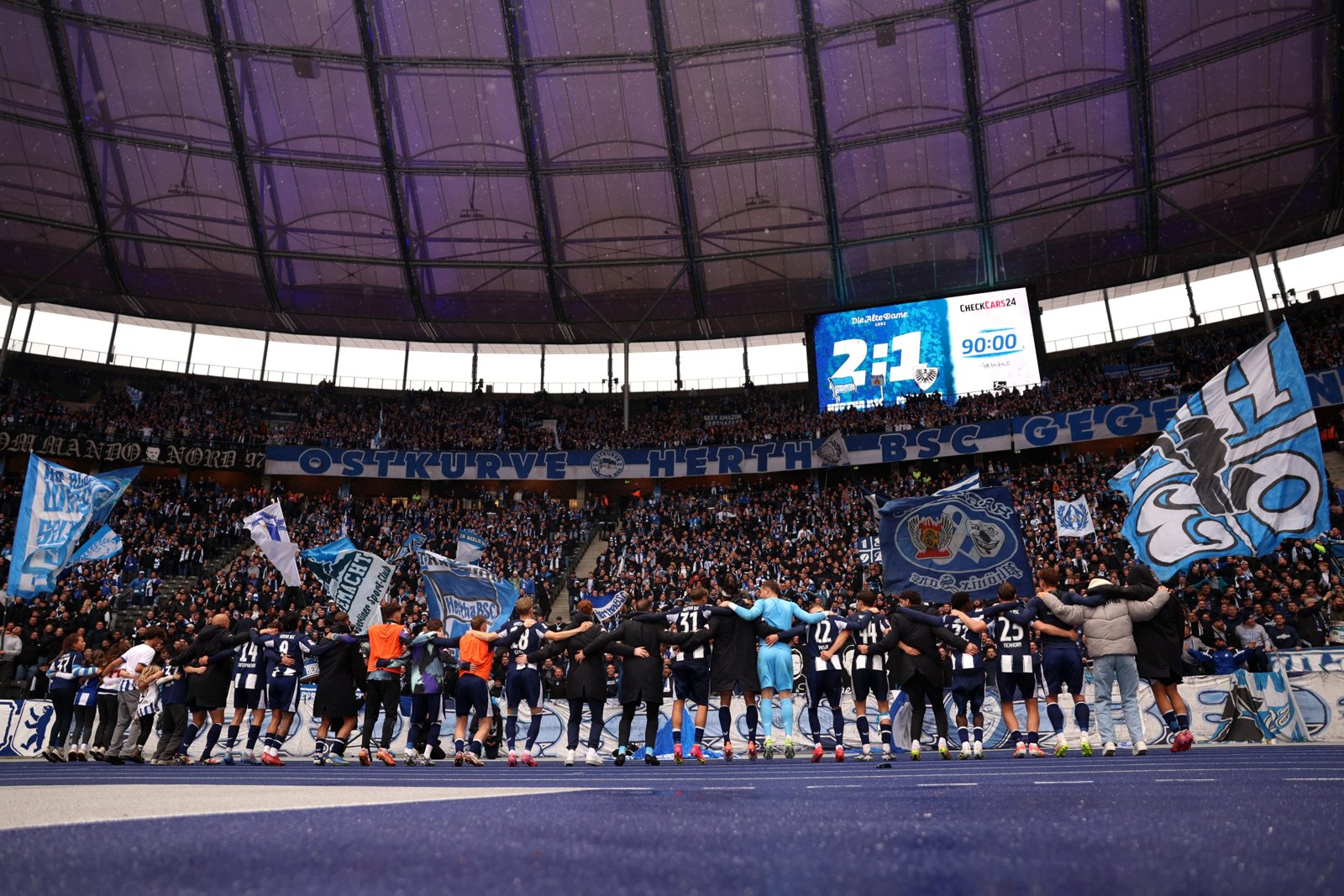 Die Mannschaft von Hertha BSC feiert Arm in Arm vor der Ostkurve im Olympiastadion